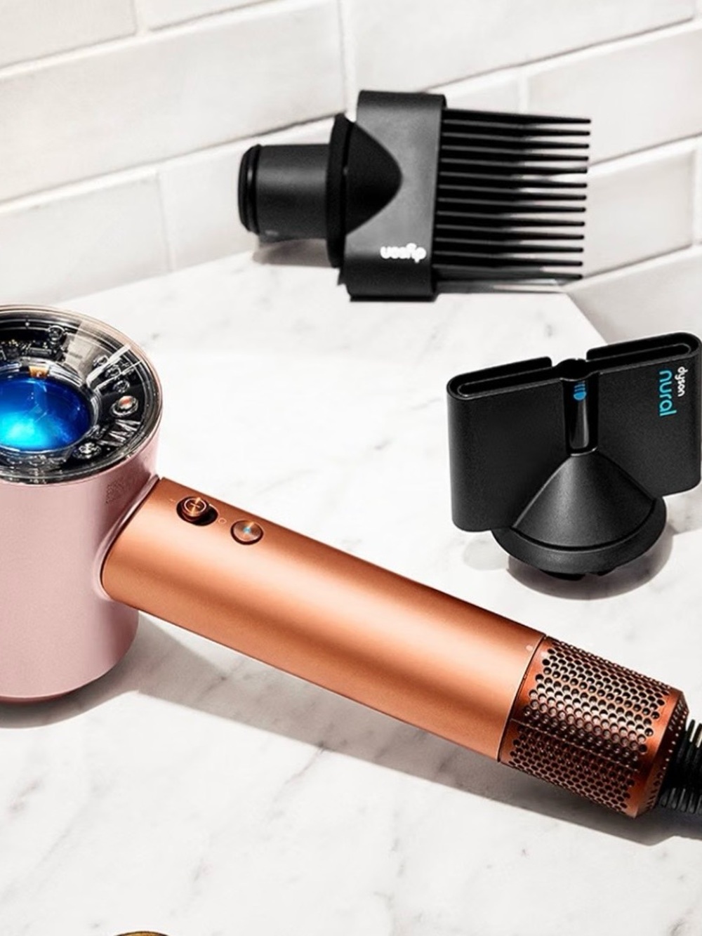 Dyson hair dryer in rose gold and copper finish with styling nozzles